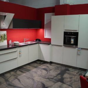 Bauformat L-Küche in weiß mit Edelstahl Griffleisten und schwarzer Arbeitsplatte