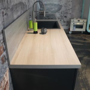 Design Inselküche in matt grau mit hellbrauner Holz Arbeitsplatte und Rückwand