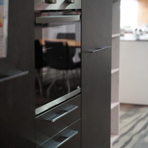 Moderne Küchenzeile in schwarz mit Wandschrank und Elektrogeräten