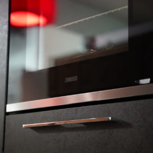 Moderne hochwertige Küchenzeile mit Wandschrank und Elektrogeräten auf Brusthöhe