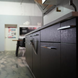 Moderne schwarze Küchenzeile mit Edelstahl Griffleisten und Wandschrank