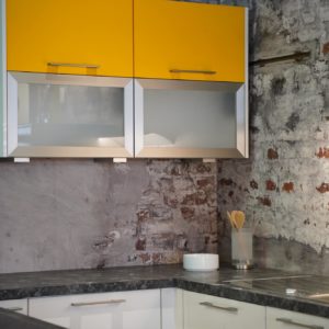 Nobilia moderne Inselküche mit gelben Hängeschrank aus Milchglas